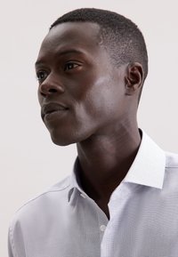 Camicia a maniche lunghe a quadri blu chiaro e bianco con colletto, caratterizzata da una superficie liscia e una vestibilità su misura.