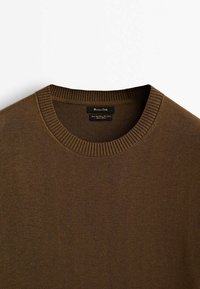 Maglione marrone lavorato a maglia con collo a girocollo a coste e texture liscia. Etichette visibili all'interno del collo, che indicano il marchio e le informazioni per la cura.
