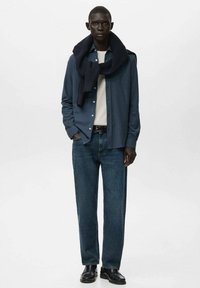 Camisa azul de botones, camiseta blanca, jeans azul oscuro, bufanda de punto marina, zapatos negros. Corte ajustado, tela suave, diseño simple, sin estampados.