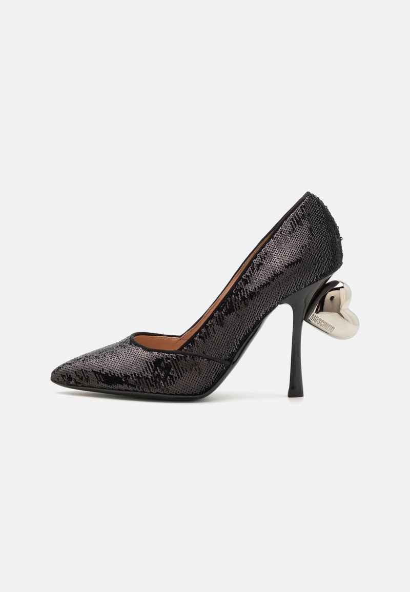 Chaussure à talon haut noire en sequins avec un bout pointu, un talon fin et un accent métallique en forme de cœur à l'arrière. Doublure intérieure lisse.