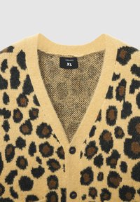 Cardigan con stampa leopardata gialla, caratterizzato da macchie nere e marroni, design a scollo a V e quattro bottoni neri. L'etichetta riporta "Terranova XL."