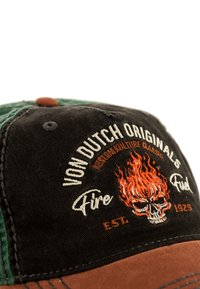 Cappellino nero e verde con ricamo di fiamme arancioni e design di teschio. Visiera marrone con dettagli di cucitura. Logo "Von Dutch Originals" visibile.