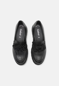 Zwarte leren loafers met gevlochten kralenversiering bovenop, maat 4½, gelabeled "Best Fitting" aan de binnenkant.