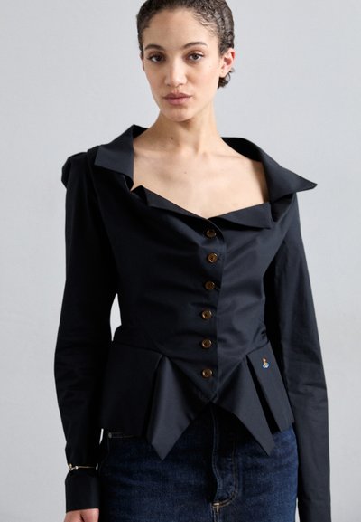 Μαύρη εφαρμοστή μπλούζα με βαθύ γιακά, καφέ κουμπιά και φούστα σε στυλ peplum. Έχει δομημένους ώμους και διακριτική κεντημένη λεπτομέρεια.