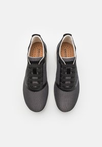 Schwarze Mesh-Sneaker mit elastischen Schnürsenkeln, strukturiertem Stoff, gepolsterten Kragen und durchlöcherten Einlegesohlen, ausgestattet mit einer glatten Gummisohle.