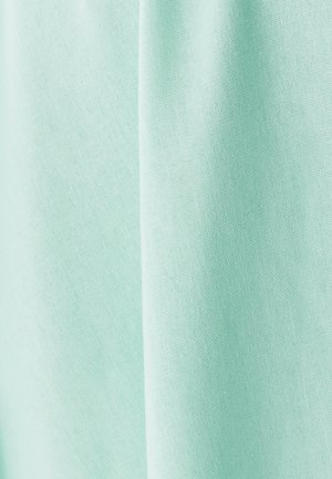 Svetlo akvamarinasto blago se nežno spušča, s gladko teksturo in fino tkanino, primerno za oblačila ali aplikacije v domači dekoraciji.