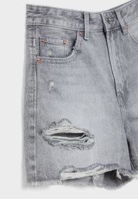 Pantalones cortos de mezclilla gris claro con desgastes, dobladillos deshilachados, remaches de cobre y cierre de botón en la parte delantera.