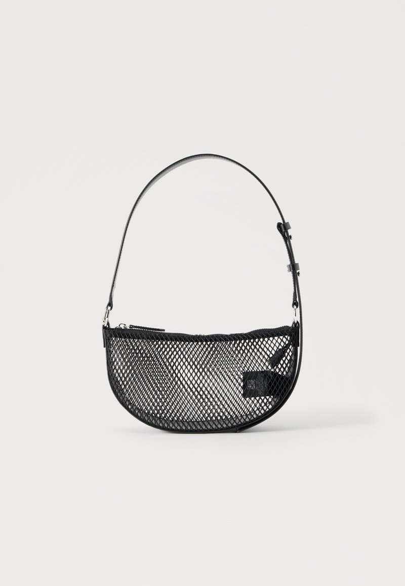 Sac à main en maille noire forme demi-lune avec une courte bandoulière en cuir réglable et une fermeture éclair sur un fond clair uni.