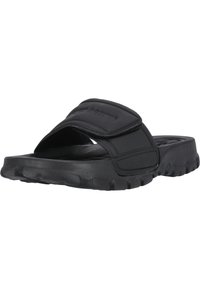 Black slide sandals with a thick rubber sole and a padded strap featuring a raised logo. The texture is smooth with a slightly glossy finish.