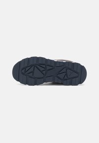 Semelle de chaussure en caoutchouc présentant un motif de semelle géométrique texturé en bleu marine, conçu pour l'adhérence et la durabilité.