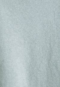 Tejido de punto azul claro con una textura de costilla fina, distribuida de manera uniforme, que muestra una superficie suave y lisa.