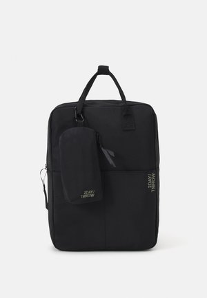 Sac à dos rectangulaire noir avec poignées supérieures et poche zippée attachée, marqué « 2DAY/TMRW », présenté sur un fond clair uni.