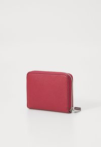 Rød lær lommebok med teksturert overflate, glidelås, og sølvfargede detaljer. Rektangulær form, kompakt design, minimalistisk stil.