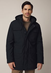 Czarna parka z kapturem, z zamkiem błyskawicznym, dwiema przednimi kieszeniami z klapą i teksturowanym wnętrzem. Idealna na zimne dni.