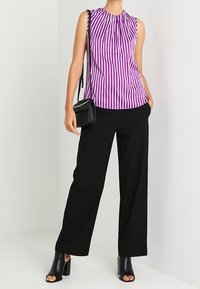 Sleeveless purple and white striped blouse with gathered neckline, paired with black wide-leg trousers and black open-toe heels.