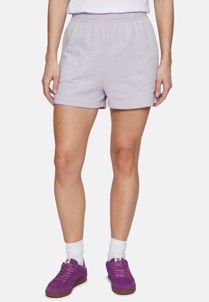 Shorts de algodón lila con cintura elástica, con un diseño sencillo y una textura suave. Se llevan con zapatillas moradas y calcetines blancos.