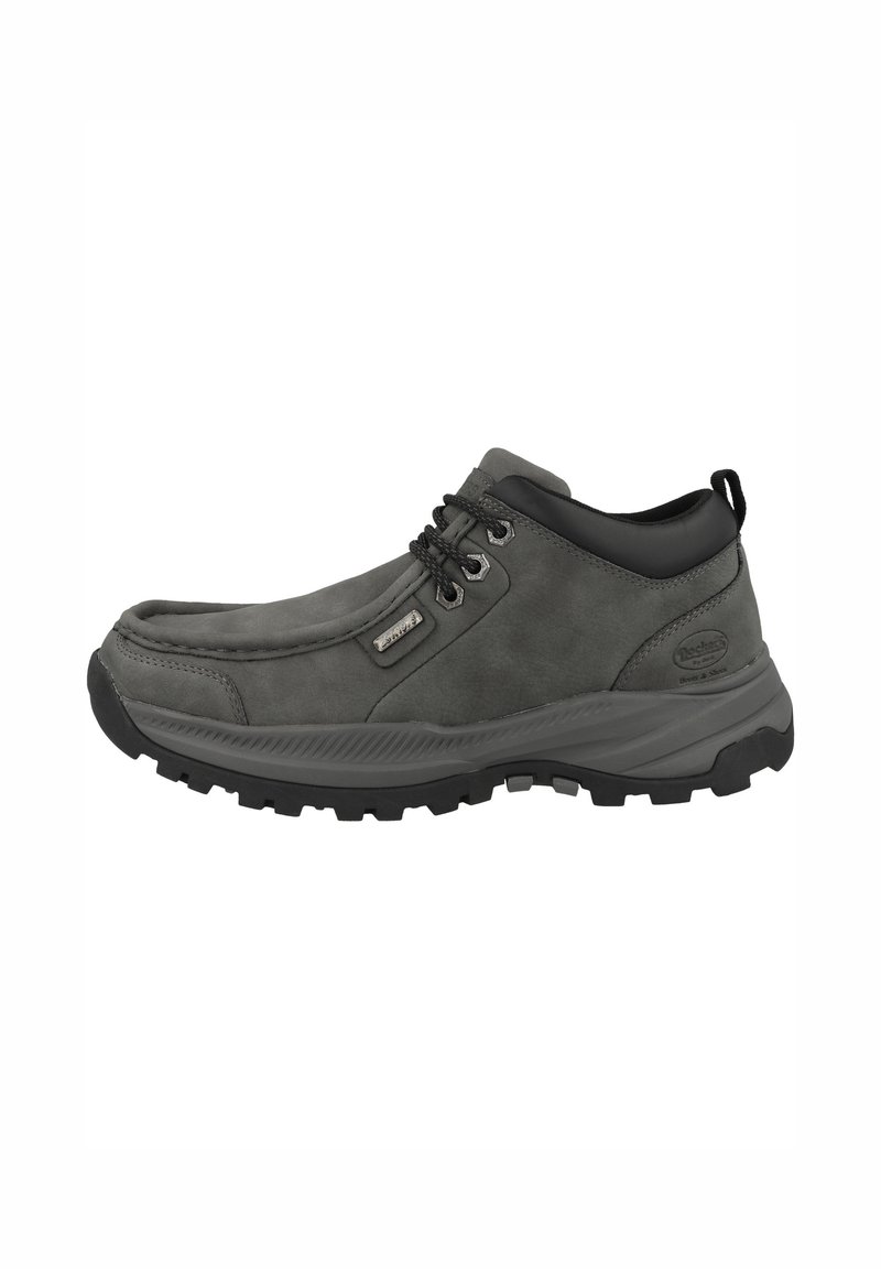 Zapato de senderismo gris hecho de ante y materiales sintéticos. Presenta acentos negros, un collar acolchado, cordones y una gruesa suela de goma con tracción.