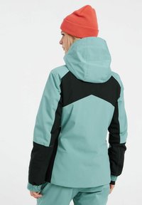 Giacca da sci turchese chiaro con design geometrico nero, cappuccio regolabile, polsini elastici e una finitura liscia e resistente alle intemperie.