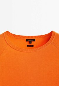 Oranges Sweatshirt mit Rundhalsausschnitt und glatter Textur. Es hat gerippte Abschlüsse am Ausschnitt und an den Schultern. Label innen sichtbar.