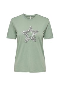 Lys grøn bomulds t-shirt med et sølvfarvet pailletstjernedesign på forsiden. Kortærmet og med rund hals. Blød tekstur.