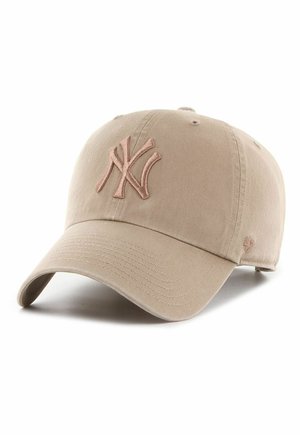 Beige Baseballkappe mit gesticktem, stilisiertem "NY"-Logo auf der Vorderseite, gebogenem Schirm und verstellbarem Rückriemen vor weißem Hintergrund.
