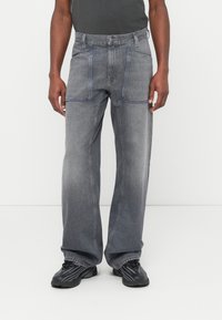 Jeans in denim grigio con vestibilità ampia, caratterizzati da cuciture blu a contrasto, cinque tasche e una classica chiusura con bottone in vita.