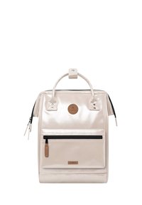 Schöner beiger Rucksack mit strukturiertem Design, ausgestattet mit einer Frontreißverschlusstasche, einem oberen Tragegriff und einem runden Logopatch.