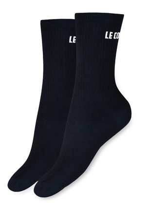 Calcetines negros con textura acanalada que presentan el texto blanco "LE COUDE" en el puño. Material blando de mezcla de algodón con una forma de calcetín estándar.