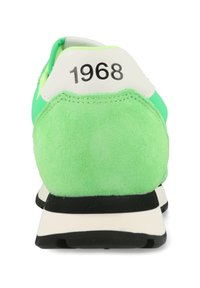 Sneaker verde con tallone in suede, accenti bianchi e suola nera. Presenta il numero "1968" sulla linguetta del tallone.