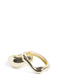 Poleeritud kuldse tooni metallringid orgaaniliste, kõverate kujudega; üks ring kattub osaliselt teisega, demonstreerides sujuvat, peegeldavat pinda.