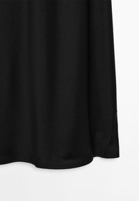 Černá látka s hladkým povrchem, s zaobleným lemem a jemným splýváním. Žádné viditelné vzory ani kovov�é detaily.