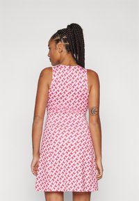 Czerwona i biała sukienka bez rękawów z wzorem, z dopasowaną górą, rozkloszowanym dołem i okrągłym dekoltem, uszyta z gładkiego materiału.