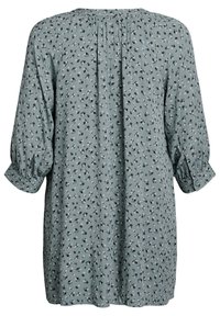 Blommönstrad klänning i en dämpad grön färg. Långa, puffiga ärmar med knappmanchetter. Lätt rynkad rygg för extra detalj.