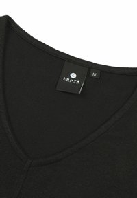 Zwarte V-hals shirt gemaakt van zacht materiaal. Het label geeft "LUHTA" aan met maat "M." Het heeft een gladde textuur en een aansluitende pasvorm.