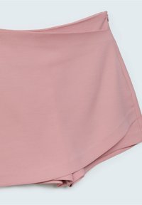 Jupe portefeuille rose avec fermeture éclair latérale cachée, texture lisse et léger détail de panneau avant superposé sur un fond clair.