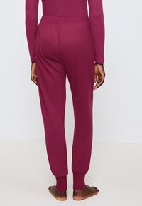 Bordeaux, taps toelopende sweatpants met een elastische tailleband en ribgebreide boorden. Glad materiaal met een relaxte pasvorm. Geen zichtbare zakken.