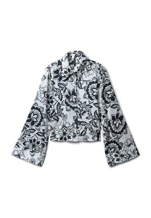 Camicia bianca con bottoni, decorata con un motivo floreale nero, maniche lunghe e larghe, e colletto a punta, mostrata distesa su uno sfondo bianco.