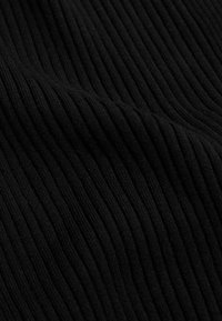 Schwarzer gerippter Stoff mit einer weichen Textur, der vertikale Linien aufweist, die ein strukturiertes Muster bilden. Das Material wirkt leicht dehnbar.