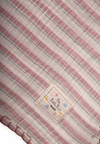 Viegls kokvilnas segas ar rozā un zilām svītrām. Iezīmēts ar šūtiem malām un etiķeti ar krāsainu debesu dizainu.