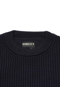 Dark navy knitted sweater with a textured, ribbed design. Features a round neckline and a label reading "HONESTY RULES."