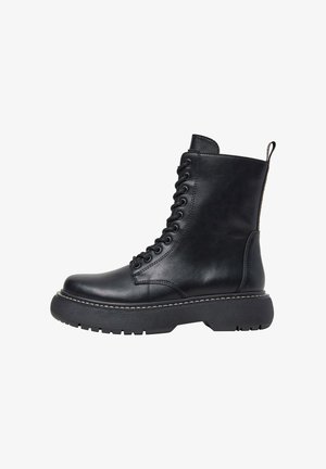 Stivale alla caviglia in pelle nera con punta tonda, design con lacci, suola spessa e dettagli di cucitura a contrasto. Caratterizzato da una linguetta sul retro.