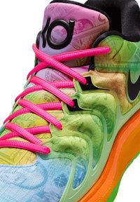 Zapatilla colorida en tonos de rosa, verde y azul con cordones vibrantes en rosa, superposiciones texturizadas y un logo negro distintivo en el costado.