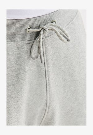 Jasnoszare dresy z ribbowanym pasem i przewiązanym sznurkiem widocznym w pobliżu przedniego szwu.