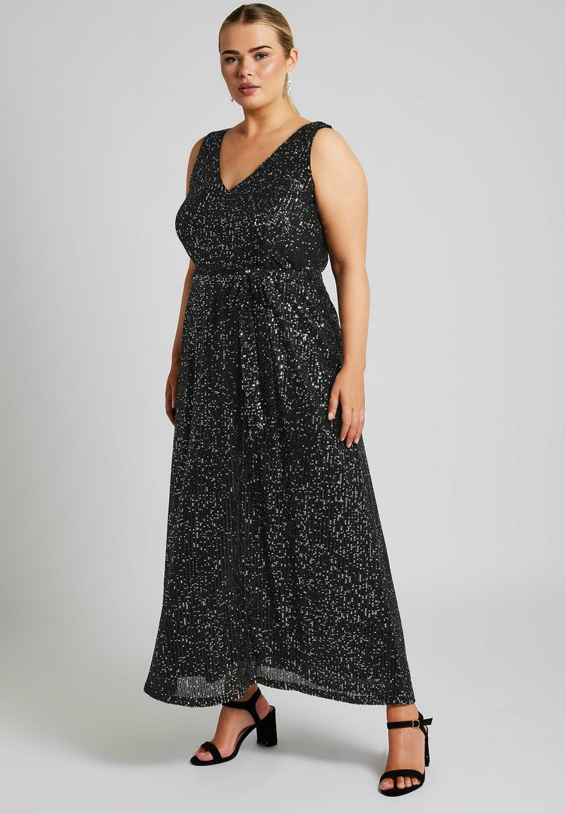 Vestido maxi negro sin mangas con escote en V, adornado con lentejuelas dispersas para dar textura. Incluye un detalle de lazo en la cintura.