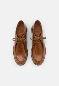 Brown leather lace-up shoes with a glossy finish, rounded toe, and contrasting tan stitched sole. Features thin brown laces.