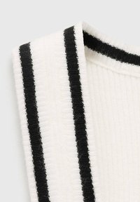 Geripptes weißes Gewebe mit zwei schwarzen horizontalen Streifen. Der Rand zeigt ein gefaltetes Design, das die Textur und die kontrastierenden Farben betont.