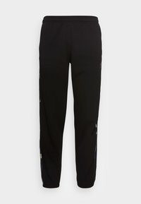 Pantalones deportivos negros con cintura elástica, ajuste ajustado y paneles laterales con un diseño geométrico. Tejido suave con una textura ligera.