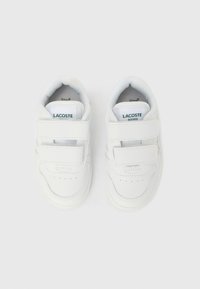 Λευκά παιδικά αθλητικά παπούτσια με εξωτερική επιφάνεια από λείο δέρμα, διαθέτουν δύο φαρδιές λουρίδες βέλκρο, οπές στην περιοχή των δαχτύλων και μπλε ετικέτα με λογότυπο.