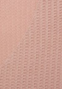 Lichtroze gebreide stof met een combinatie van gestructureerde patronen en open weefsels, waardoor een zachte en ademende oppervlakte ontstaat.