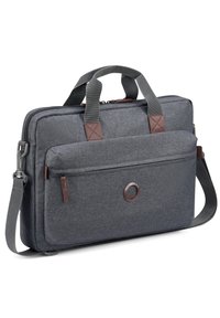 Bolsa de portátil de tela gris con dos asas superiores, tira de hombro ajustable, compartimento principal con cierre, bolsillo frontal y detalles en marrón.
